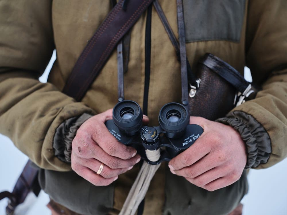 A person holding binoculars outdoors